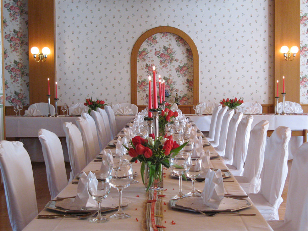 Festlich eingedeckte Hochzeitstafel mit frischen Blumen und romantischen Kerzenleuchtern im Hotel Landhotel Kern in Bad Zwesten